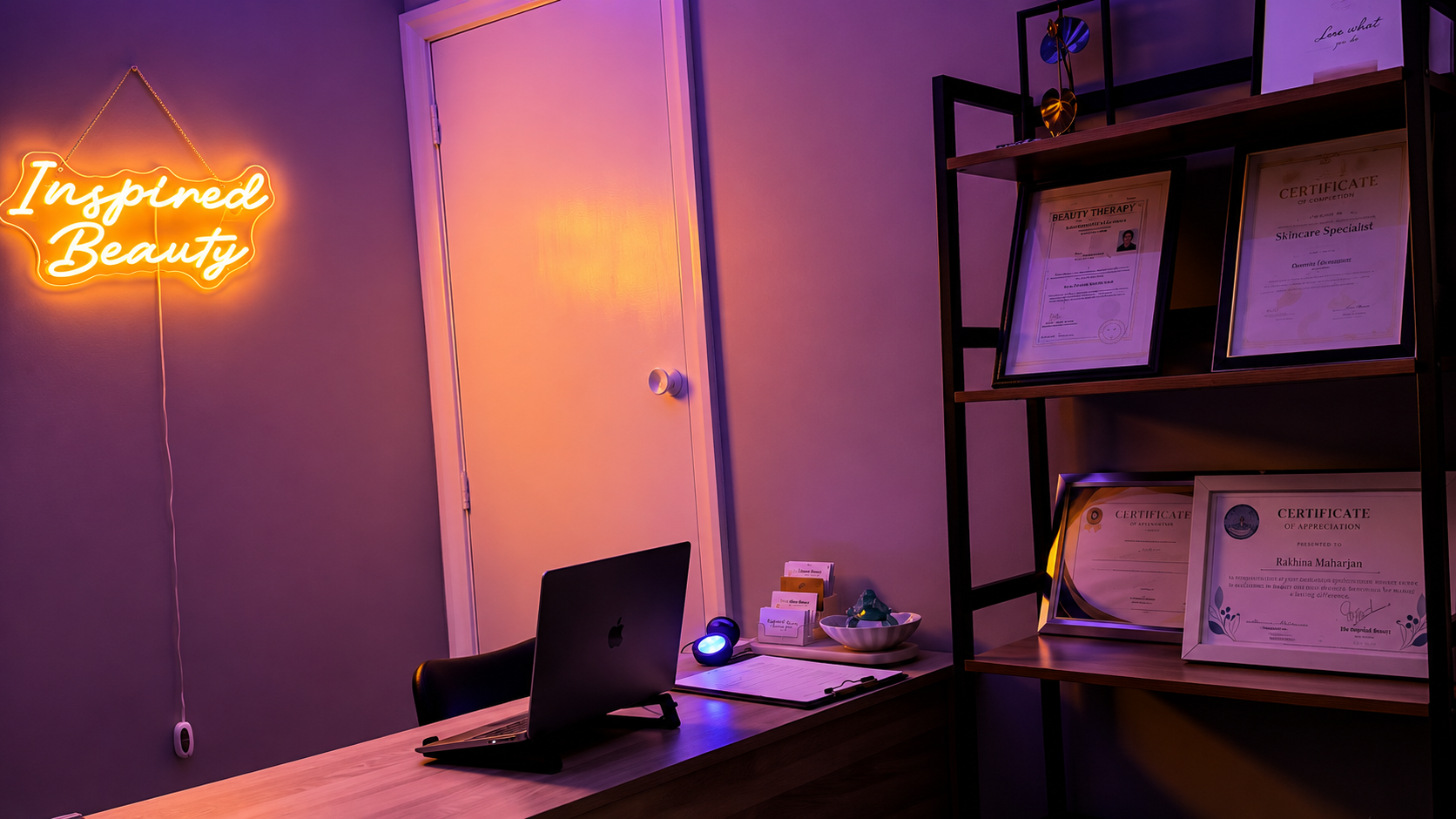 The studio corner with the Inspired Beauty neon sign and framed certificates