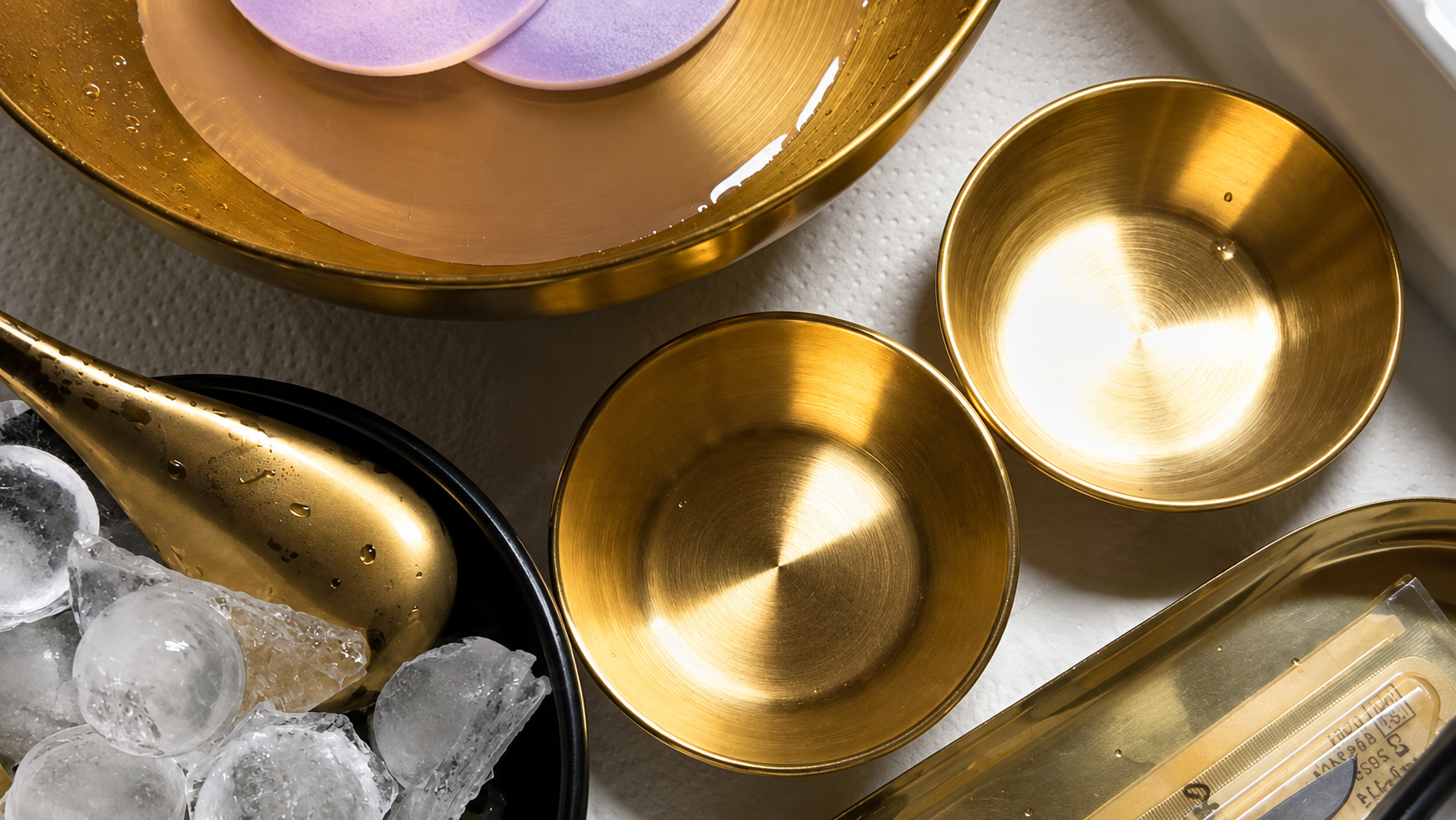 Gold treatment bowls, tools and ice arranged on a tray